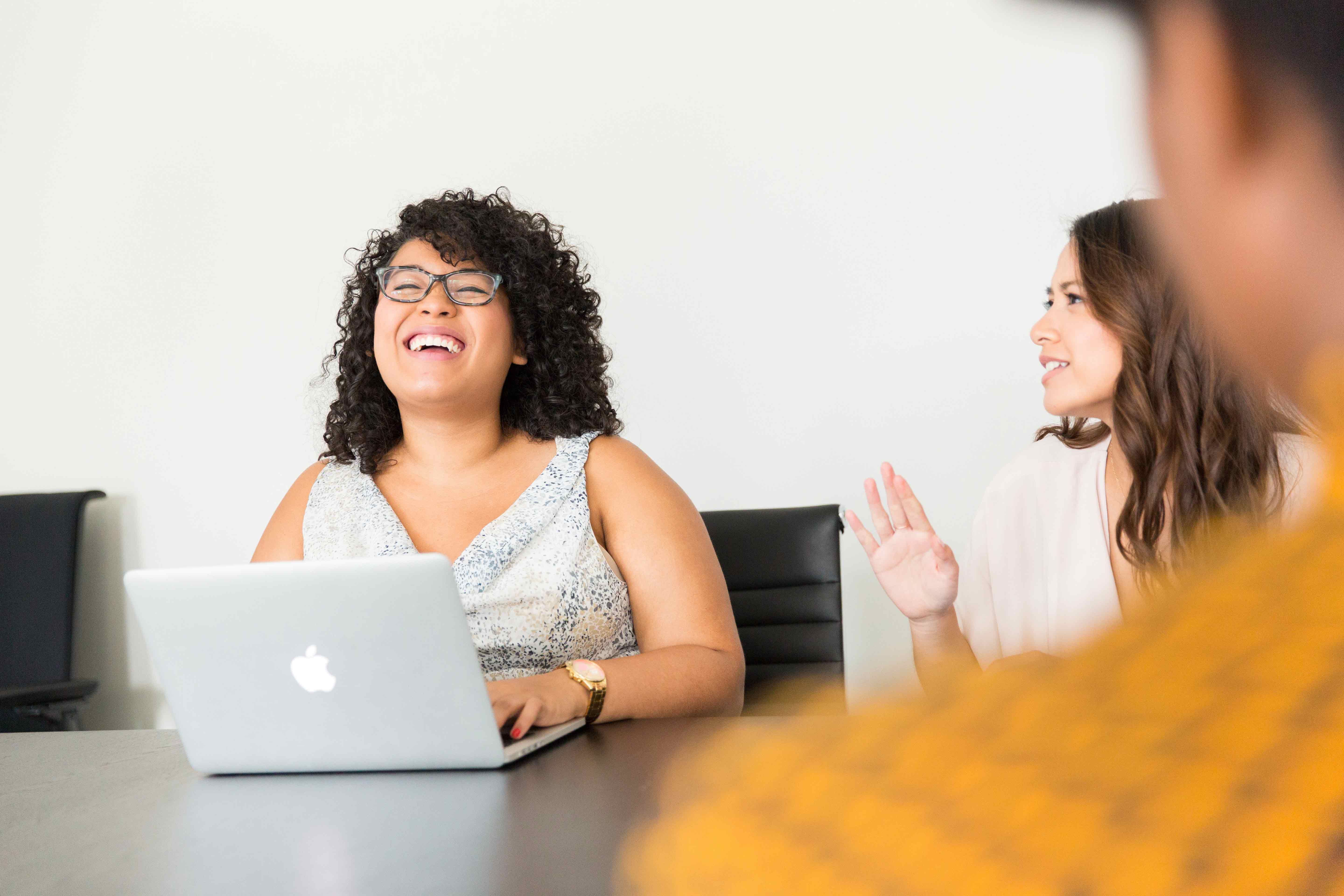 female entrepreneurs smiling in a meeting.